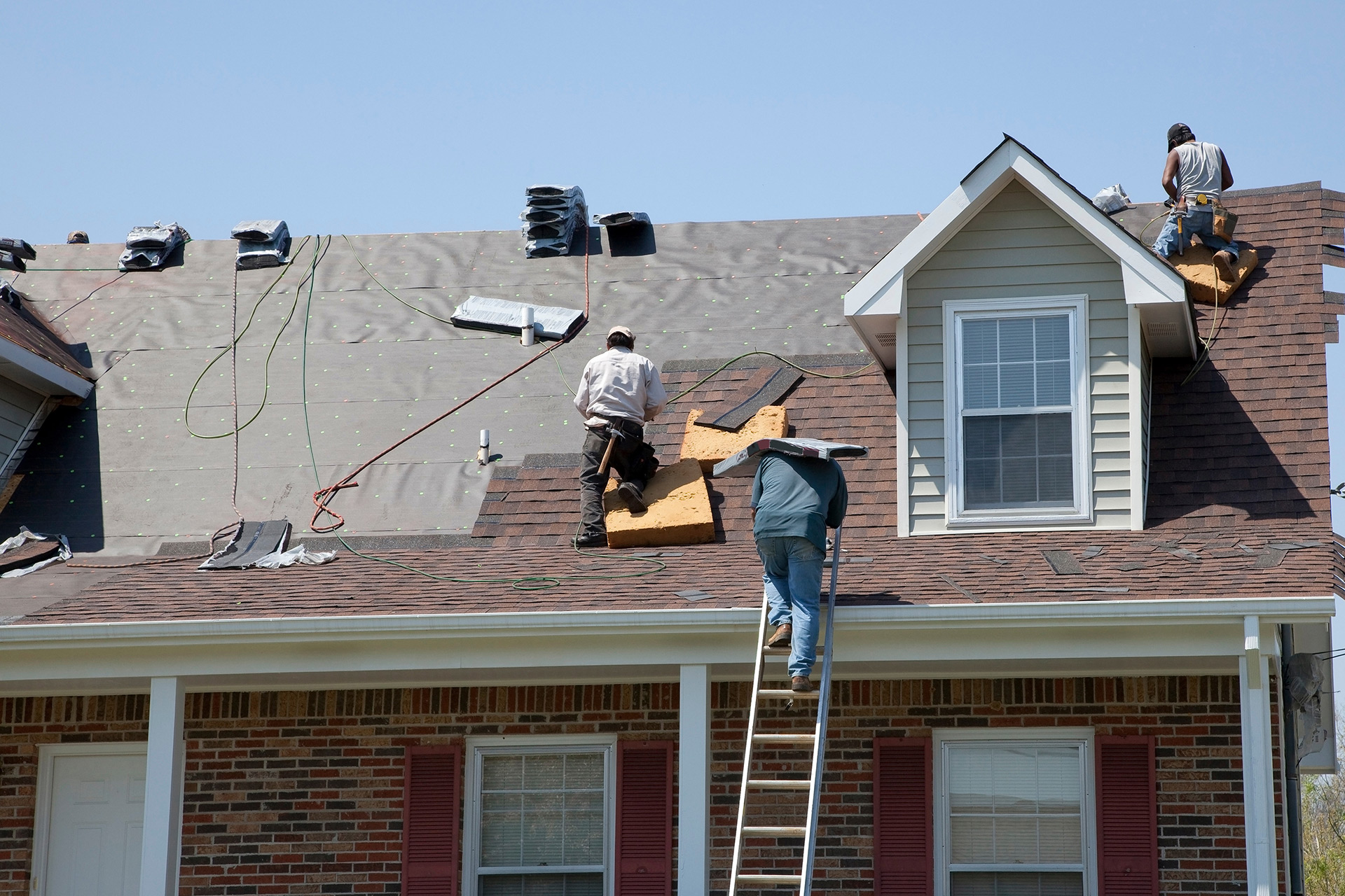 Professional roof replacement and repair - American Exteriors Roofing & Construction crew working on residential roofing in Tulsa